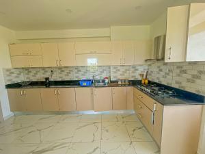 a kitchen with white cabinets and a counter top at Aqua kingstone apartments in Mombasa