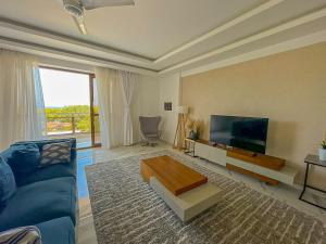 a living room with a blue couch and a flat screen tv at Aqua kingstone apartments in Mombasa