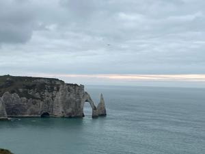 a large cliff in the ocean with the sky at Chambre & Caux in Thiergeville