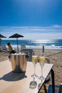 a bucket of champagne and two glasses on a table at the beach at Beach Blessing in Isla Plana