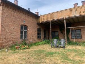 two chairs sitting outside of a brick building at Gute Vingård in Havdhem