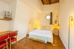 a bedroom with a bed and a table and a clock at Grande Péniche Climatisée avec Terrasse - Proche Paris in Puteaux