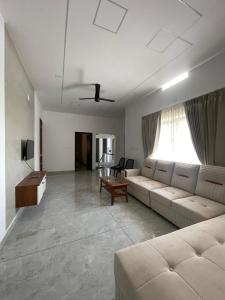 a living room with a couch and a table at Vijay Home Stays in Batheri