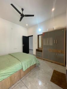 a bedroom with a bed and a ceiling fan at Vijay Home Stays in Batheri
