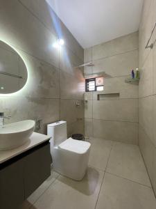 a bathroom with a white toilet and a sink at Vijay Home Stays in Batheri
