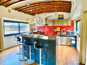a kitchen with a large counter with stools in it at Grande Péniche Climatisée avec Terrasse - Proche Paris in Puteaux