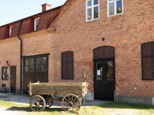 a wooden cart in front of a brick building at Gute Vingård in Havdhem +12 photos