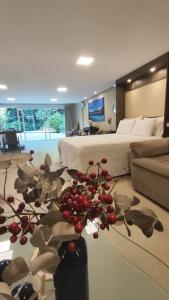 a hotel room with a bed and a vase with a plant at Casaloft994 in Bento Gonçalves +24 photos