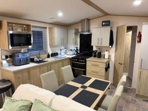 a kitchen and dining room with a table and a kitchen with at S&K Lodge Billing Aquadrome Holiday Park, Great billing ,Northampton , NN3 9DA in Northampton