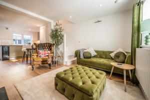 a living room with a green couch and a table at Pink Cottage, Leiston in Leiston