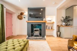 a living room with a fireplace and a tv at Pink Cottage, Leiston in Leiston