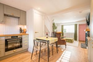a kitchen with a table with a bottle of wine on it at Pink Cottage, Leiston in Leiston +11 photos