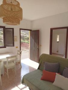 a living room with a green couch and a table at Tranquil Villa La cabaa Galdar in Gáldar