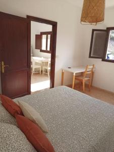 a bedroom with a bed and a table and a dining room at Tranquil Villa La cabaa Galdar in Gáldar