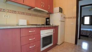 a kitchen with red cabinets and a white appliance at Tranquil Villa La cabaa Galdar in Gáldar +23 photos