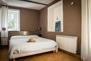 a bedroom with a bed with a hat on it at L'Oustalou in Rosières