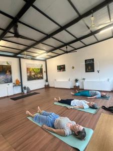 a group of people laying on the floor in a yoga class at Lake view Resort cherai in Cherai Beach