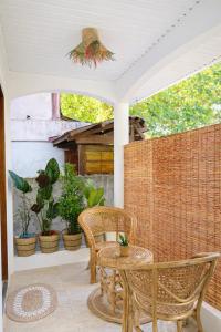 a patio with a table and chairs and plants at Lelija Apartment in General Luna