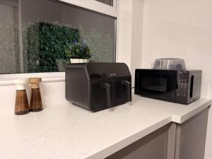 a microwave and a toaster oven sitting on a counter at Contractor Friendly 4 Bed House XBOX Sleeps 6 in Newark-on-Trent