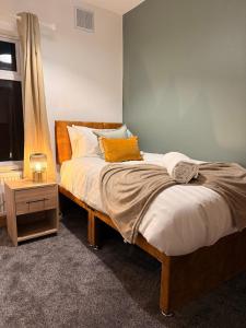 a bedroom with a bed with a night stand and a window at Contractor Friendly 4 Bed House XBOX Sleeps 6 in Newark-on-Trent