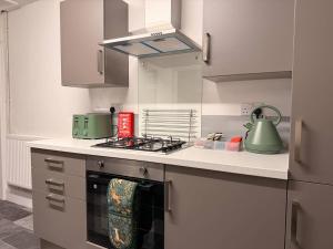 a kitchen with a stove and a green tea kettle at Contractor Friendly 4 Bed House XBOX Sleeps 6 in Newark-on-Trent