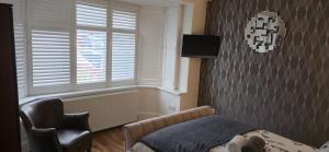 a bedroom with a bed and a chair and a window at Apple House Wembley in Barnet