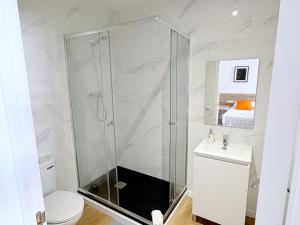a bathroom with a shower and a toilet and a sink at Hamilton Suites in Barcelona