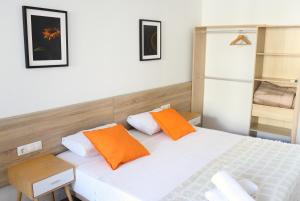 a bedroom with a white bed with orange pillows at Hamilton Suites in Barcelona +11 photos