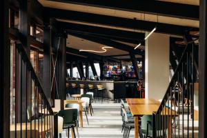 a restaurant with tables and chairs and a bar at La Cachette, Friendly Hotel & Spa in Arc 1600