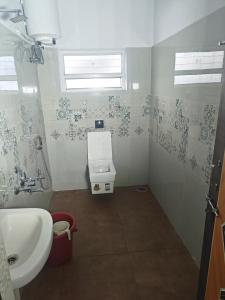 a small bathroom with a toilet and a sink at Sanctuary by JVS Palace in Hindupur