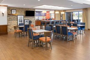 a restaurant with tables and chairs and a bar at Hampton Inn Frostburg in Frostburg