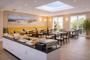 a restaurant with tables and chairs with food on display at Hotel zur Traube in Kühlungsborn