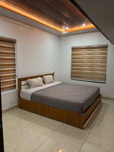 a bedroom with a bed and two windows at ARAMAM SERVICE VIlla in Mananthavady