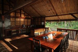 a dining room with a wooden table and chairs at Palawan Ecolodge in Malabuñgan