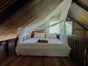 a bedroom with a bed with two shoes on it at Palawan Ecolodge in Malabuñgan