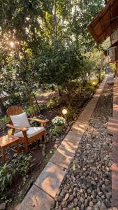 a bench sitting in a garden with rocks and trees at Abraham's 4 BHK villa, By Gonserv in Jāmb