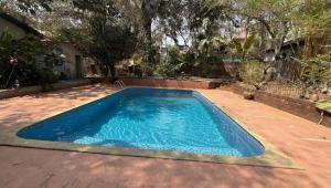 a large blue swimming pool in a yard at Abraham's 4 BHK villa, By Gonserv in Jāmb