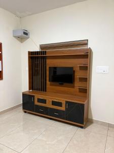 a entertainment center with a television on a wall at ARAMAM SERVICE VIlla in Mananthavady