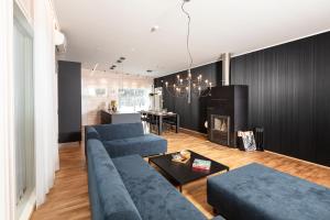 a living room with a blue couch and a fireplace at Villa Kannas 1 in Juuka