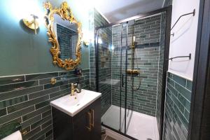 a bathroom with a sink and a shower with a mirror at Ricky Road Guest House in Watford