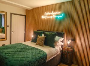 a bedroom with a bed with a green comforter at Ricky Road Guest House in Watford