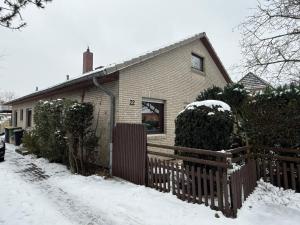 a house with a fence in the snow at Schicke kleine Bude (Pretty tiny Flat) in Neuenkirchen