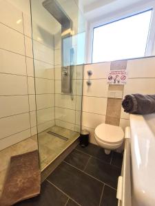 a bathroom with a shower with a toilet and a sink at Moderne Wohnung mit Balkon und top Anbindung in Unna