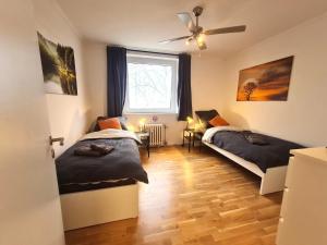 a bedroom with two beds and a window at Moderne Wohnung mit Balkon und top Anbindung in Unna