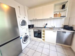 a kitchen with a washer and dryer in it at Moderne Wohnung mit Balkon und top Anbindung in Unna +5 photos