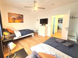 a living room with two beds and a television at Moderne Wohnung mit Balkon und top Anbindung in Unna