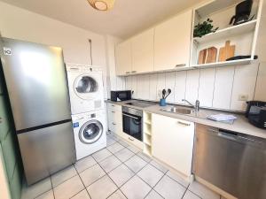 a kitchen with a refrigerator and a washer and dryer at Moderne Wohnung mit Balkon und top Anbindung in Unna
