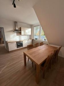 a large kitchen with a wooden table and chairs at Ferienwohnung Meyer in Neuenkirchen