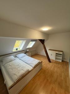 a bedroom with a bed in a room with two windows at Ferienwohnung Meyer in Neuenkirchen