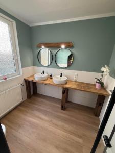 a bathroom with two sinks and two mirrors at Ferienwohnung Meyer in Neuenkirchen +9 photos
